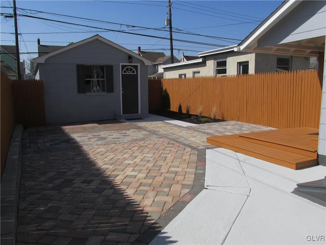 view of patio with an outbuilding and fence