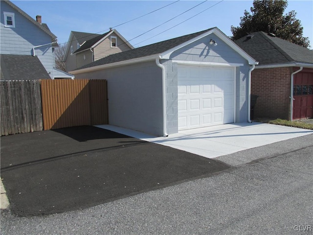 garage featuring fence and driveway