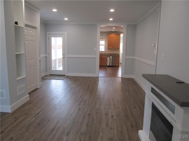 unfurnished living room featuring recessed lighting, baseboards, dark wood-style floors, and crown molding