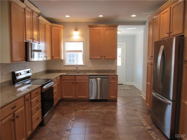 kitchen with decorative backsplash, a healthy amount of sunlight, stainless steel appliances, and a sink