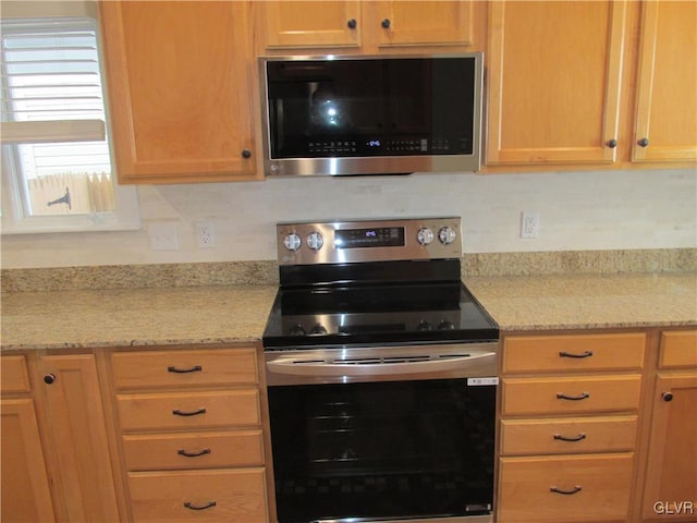 kitchen featuring light stone counters and appliances with stainless steel finishes