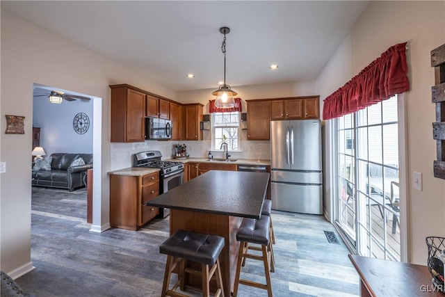 kitchen with a sink, stainless steel appliances, tasteful backsplash, and visible vents