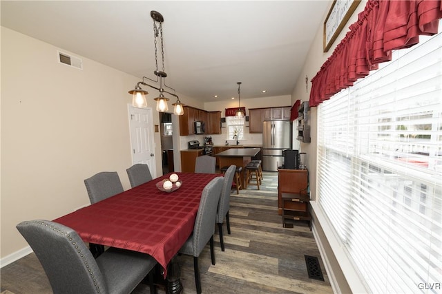 dining space featuring visible vents, baseboards, and dark wood finished floors