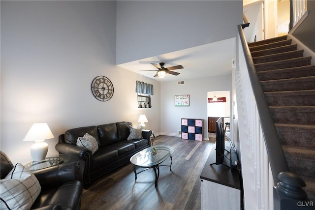 living room featuring visible vents, a ceiling fan, dark wood-style flooring, and stairs