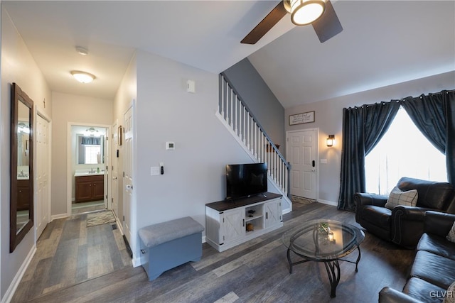 living area with stairs, wood finished floors, a ceiling fan, and baseboards