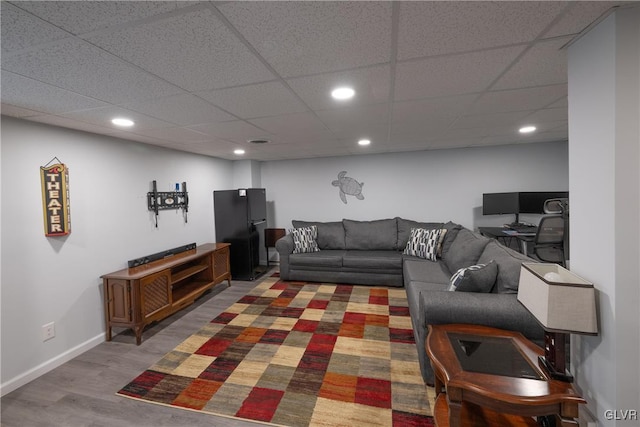 living area featuring recessed lighting, a paneled ceiling, baseboards, and wood finished floors