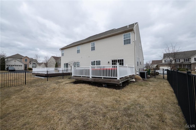 rear view of property featuring a lawn, a fenced backyard, a residential view, a wooden deck, and central AC unit