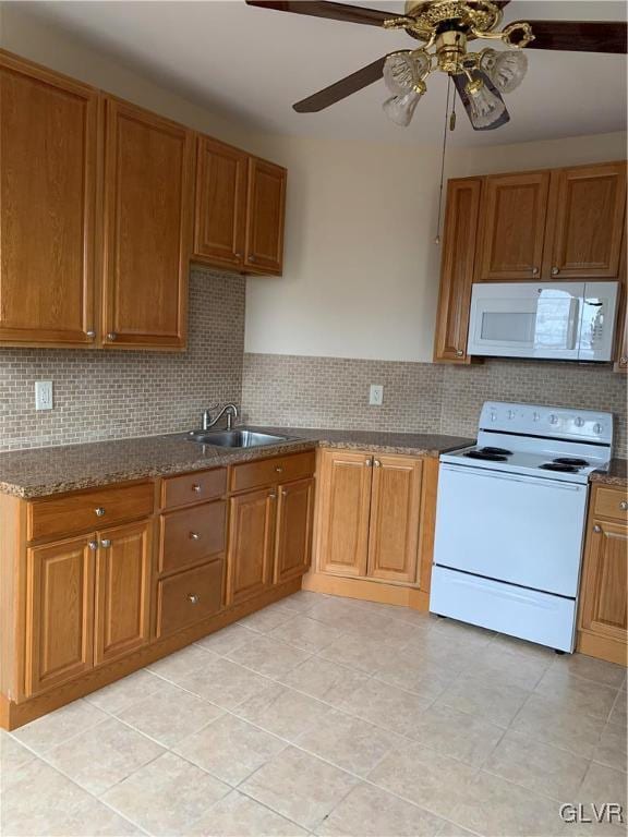 kitchen with tasteful backsplash, brown cabinets, white appliances, a ceiling fan, and a sink