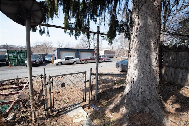 view of yard with a gate, an outbuilding, and fence