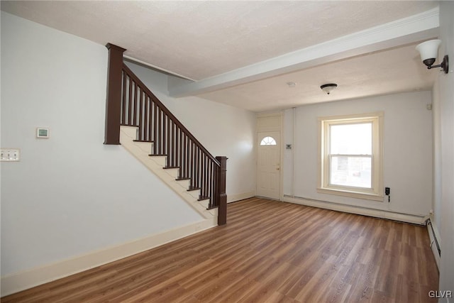 foyer featuring beamed ceiling, wood finished floors, a baseboard radiator, baseboards, and stairs