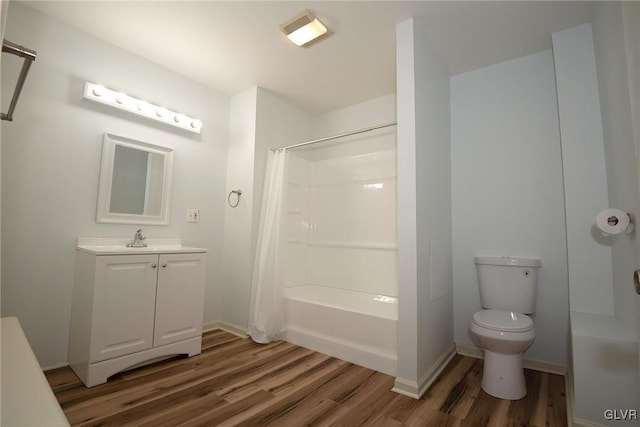 full bathroom featuring toilet, vanity, baseboards, and wood finished floors