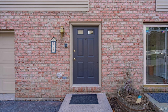 view of exterior entry featuring brick siding