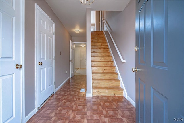 interior space with stairway and baseboards