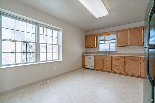 kitchen featuring visible vents, freestanding refrigerator, light countertops, baseboards, and dishwasher