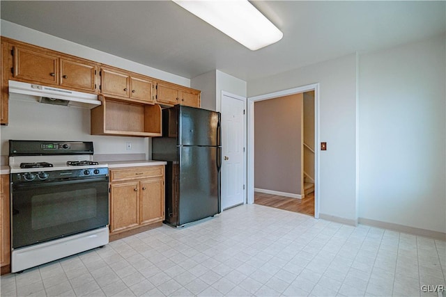 kitchen featuring under cabinet range hood, freestanding refrigerator, light countertops, baseboards, and white gas range