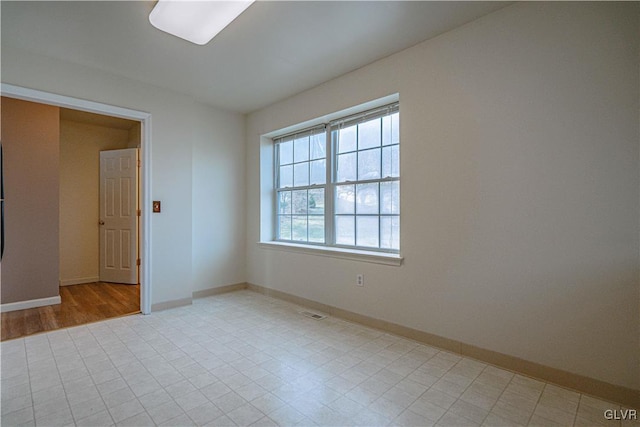 spare room featuring visible vents and baseboards