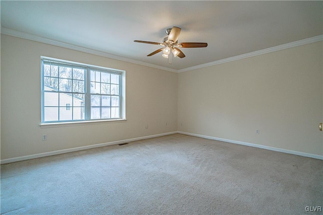 carpeted spare room with visible vents, baseboards, ceiling fan, and ornamental molding