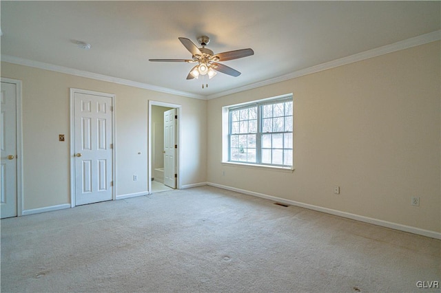 unfurnished bedroom with visible vents, baseboards, ceiling fan, ornamental molding, and carpet flooring