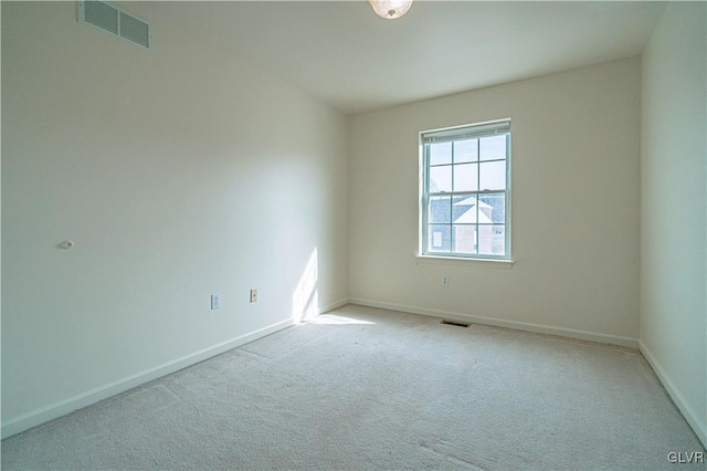 carpeted spare room with visible vents and baseboards