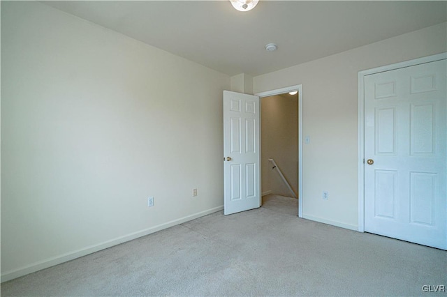 unfurnished bedroom with light colored carpet and baseboards