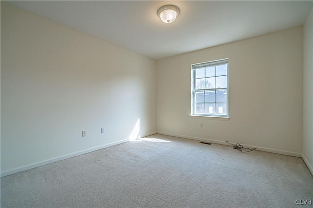 spare room with baseboards and carpet