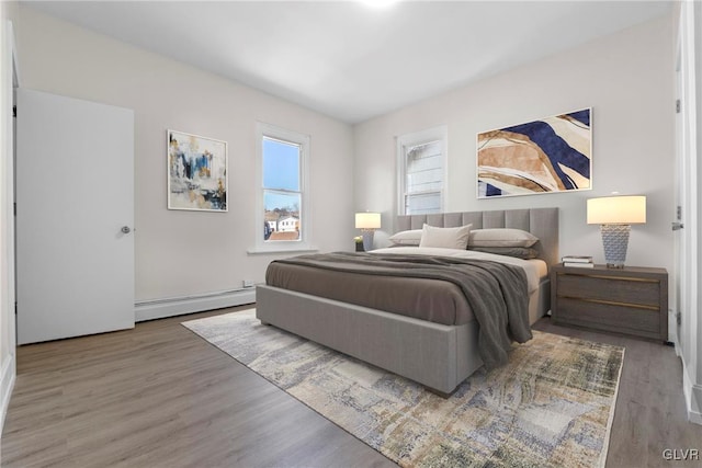 bedroom featuring baseboard heating and wood finished floors