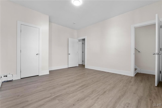 unfurnished bedroom featuring light wood-style flooring and baseboards