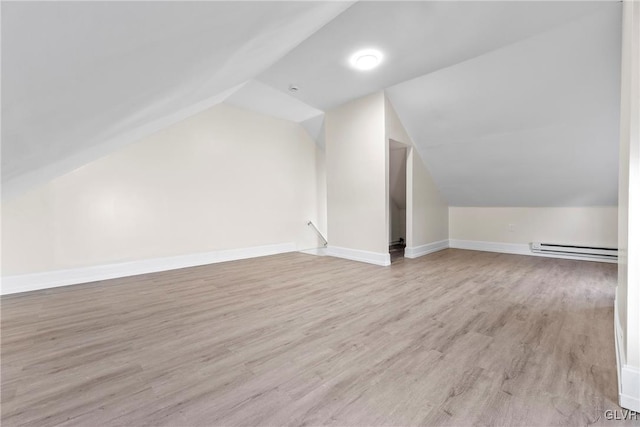 bonus room featuring baseboards, baseboard heating, wood finished floors, and vaulted ceiling