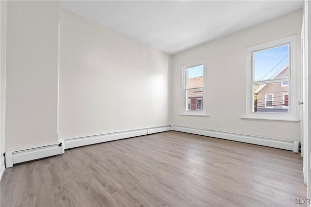 spare room featuring wood finished floors and baseboard heating