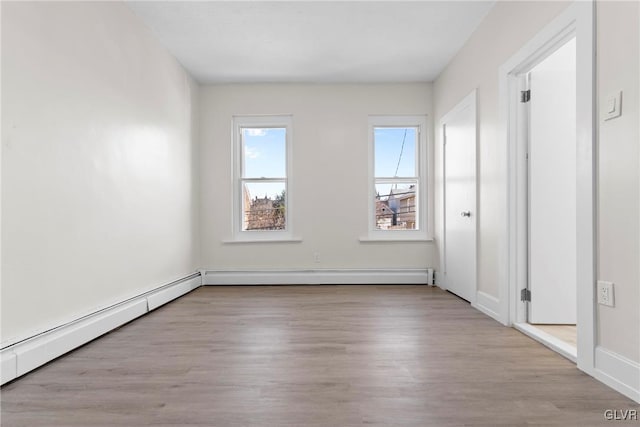 unfurnished bedroom with a baseboard radiator and wood finished floors