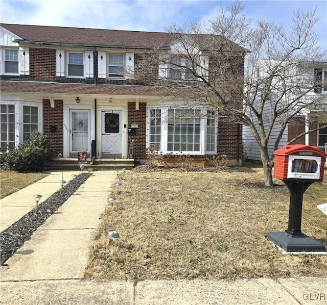 view of front of property with brick siding and a shingled roof