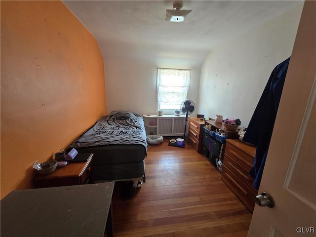 bedroom with radiator heating unit and hardwood / wood-style flooring