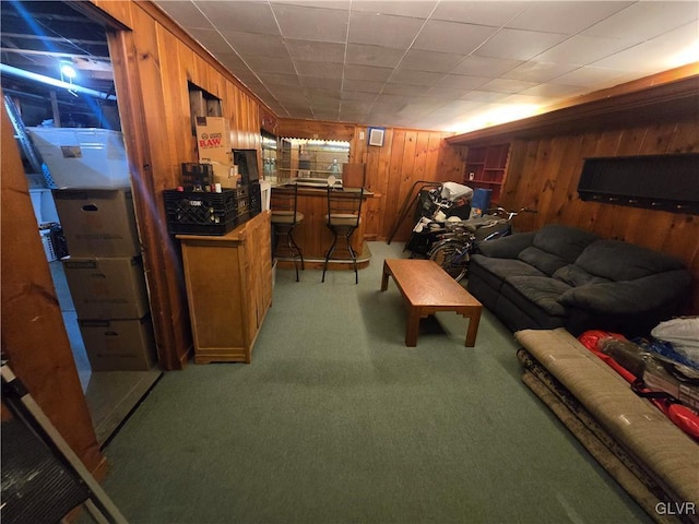 living room featuring light carpet, wooden walls, and a bar