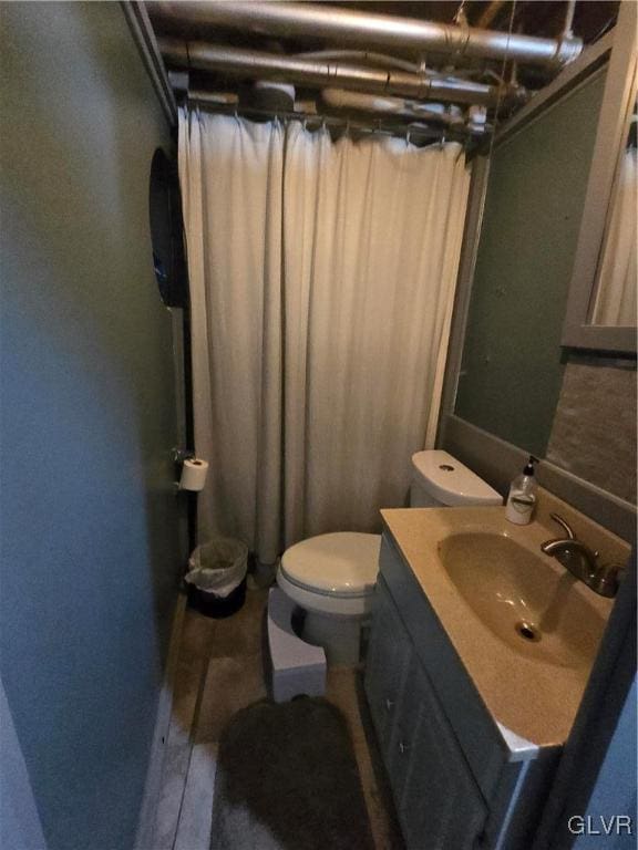 bathroom with toilet, vanity, and a shower with curtain