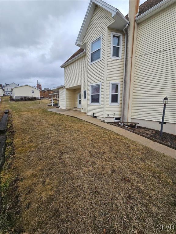 back of property featuring a lawn and a patio