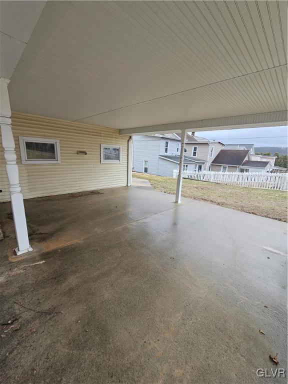 view of patio / terrace featuring an attached carport and fence