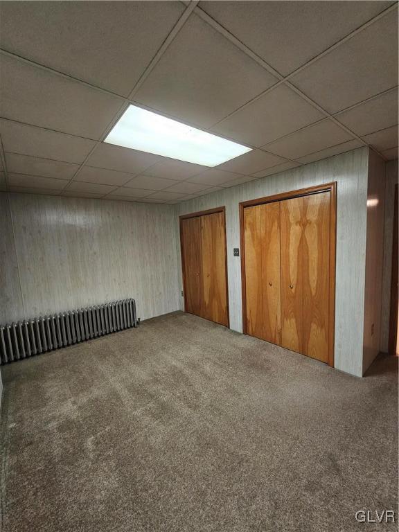 basement with carpet and a drop ceiling