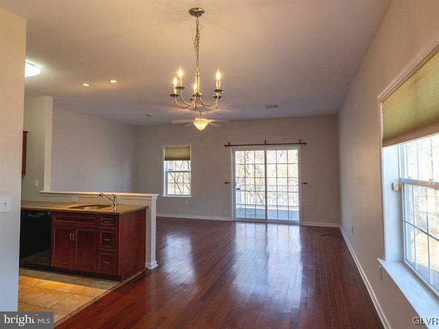 kitchen with a sink, black dishwasher, a peninsula, and open floor plan