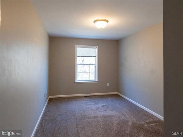 unfurnished room with carpet and baseboards