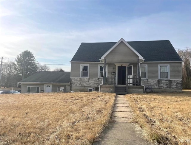 view of front of home with stone siding, a porch, and a shingled roof