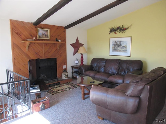 carpeted living area featuring beamed ceiling