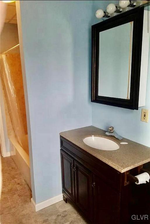 515 N Railroad St, Tamaqua Borough, PA 18252 - bathroom with vanity, shower / tub combo, and baseboards