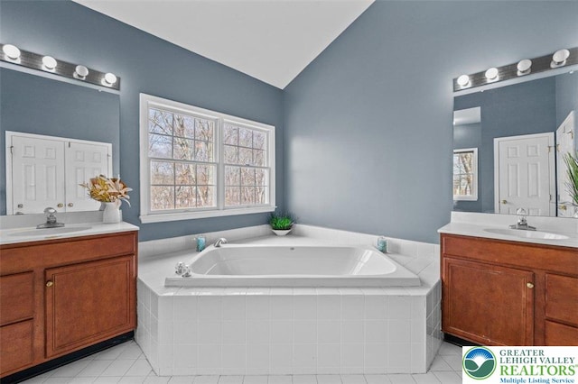 255 Rising Meadow Way E, Stroudsburg, PA 18302 - bathroom with two vanities, vaulted ceiling, tile patterned flooring, and a bath