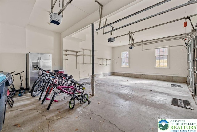255 Rising Meadow Way E, Stroudsburg, PA 18302 - garage featuring a garage door opener and stainless steel refrigerator with ice dispenser