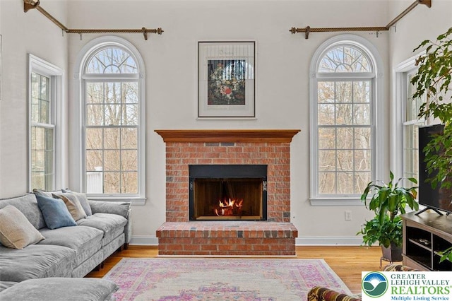 255 Rising Meadow Way E, Stroudsburg, PA 18302 - living area with healthy amount of natural light, wood finished floors, and a brick fireplace