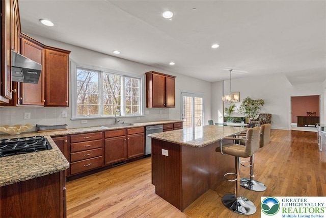 255 Rising Meadow Way E, Stroudsburg, PA 18302 - kitchen with ventilation hood, dishwasher, black gas cooktop, light wood-type flooring, and a kitchen bar