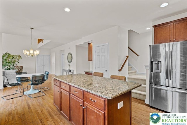 255 Rising Meadow Way E, Stroudsburg, PA 18302 - kitchen featuring stainless steel fridge with ice dispenser, light wood-type flooring, a chandelier, a kitchen island, and light stone counters