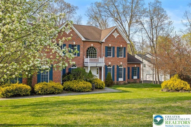 255 Rising Meadow Way E, Stroudsburg, PA 18302 - colonial-style house featuring brick siding, a front lawn, and a balcony