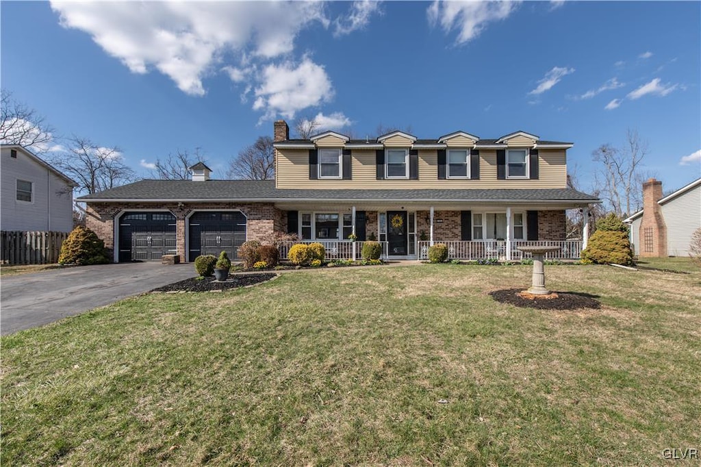 33 Alpine Dr, Palmer Twp, PA 18045 - view of front facade featuring driveway, a chimney, an attached garage, a front lawn, and a porch