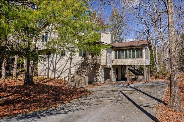 367 Saunders Dr, Lehman Twp, PA 18324 - view of front of home with a sunroom, driveway, stairway, and a chimney